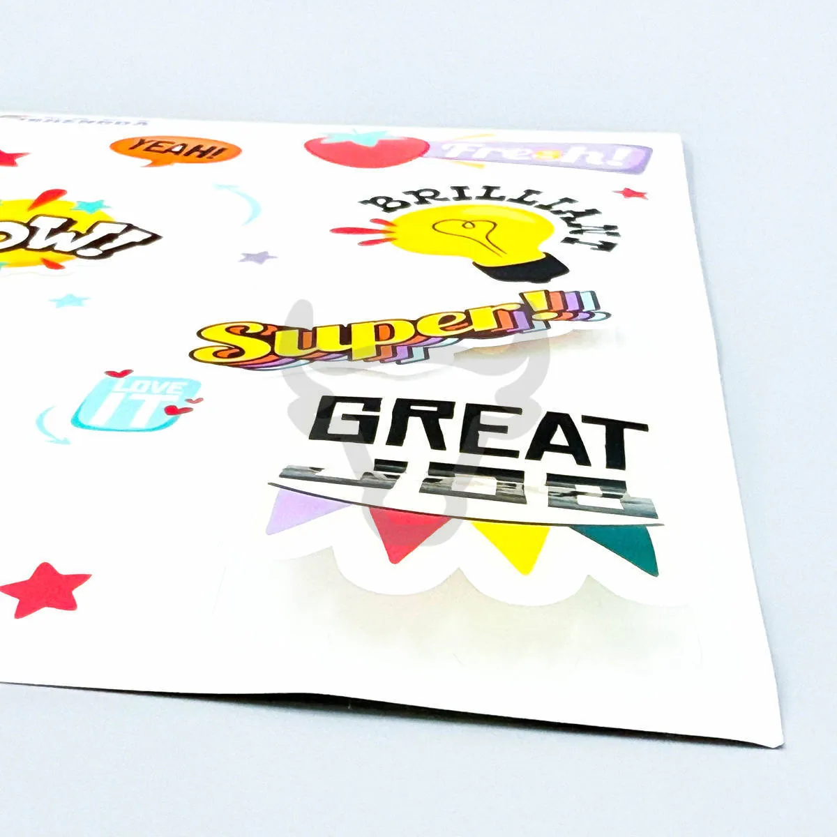Glossy printed sticker sheet reflecting light.